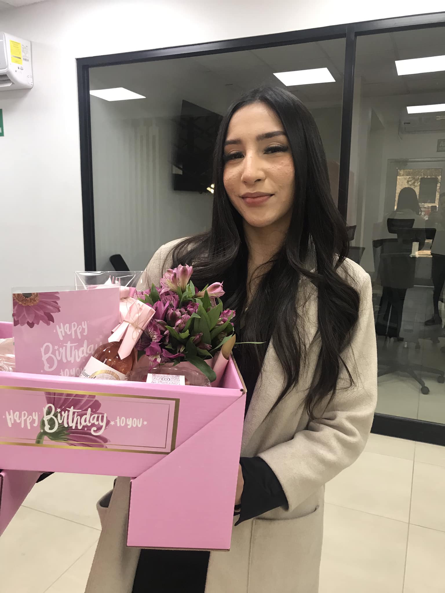 Un empleado sonriente recibiendo un elegante desayuno sorpresa en su escritorio de oficina, como un gesto de agradecimiento o celebración empresarial.
